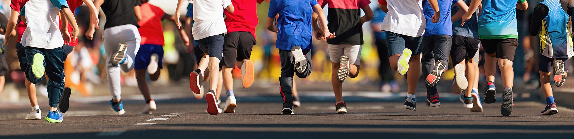 Children running on a road, feet only