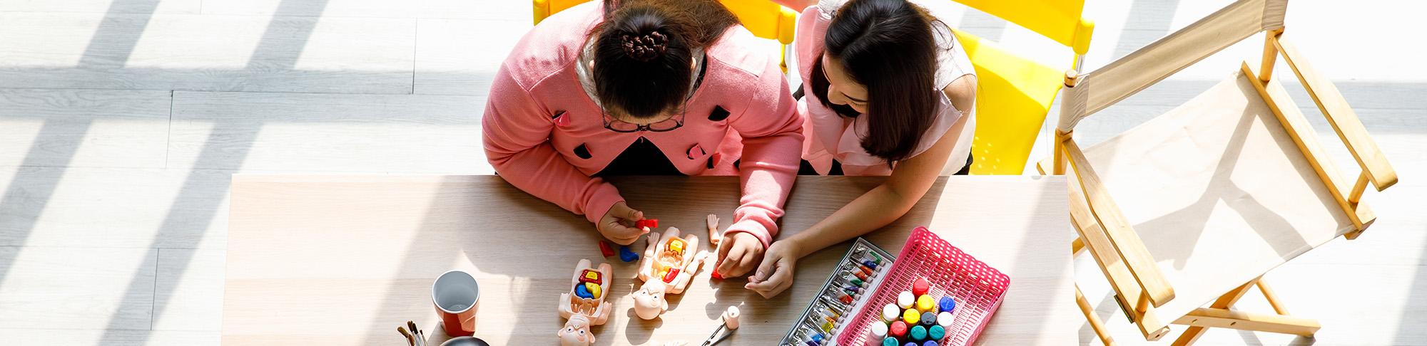 A teacher working with a student on blocks