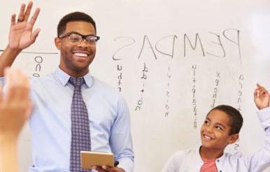 Black male teacher leads a class of elementary-age students